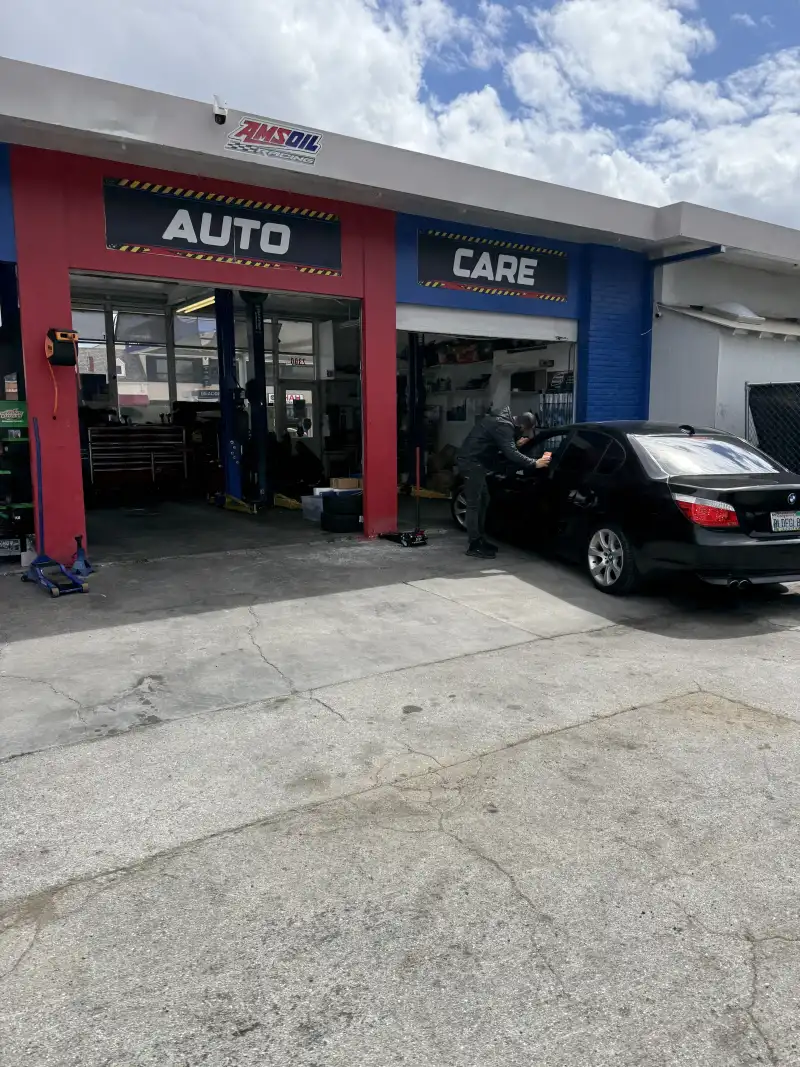 A Beacon Auto Care technician working on a BMW at the San Mateo shop — the work behind the 24-month parts-and-labor warranty