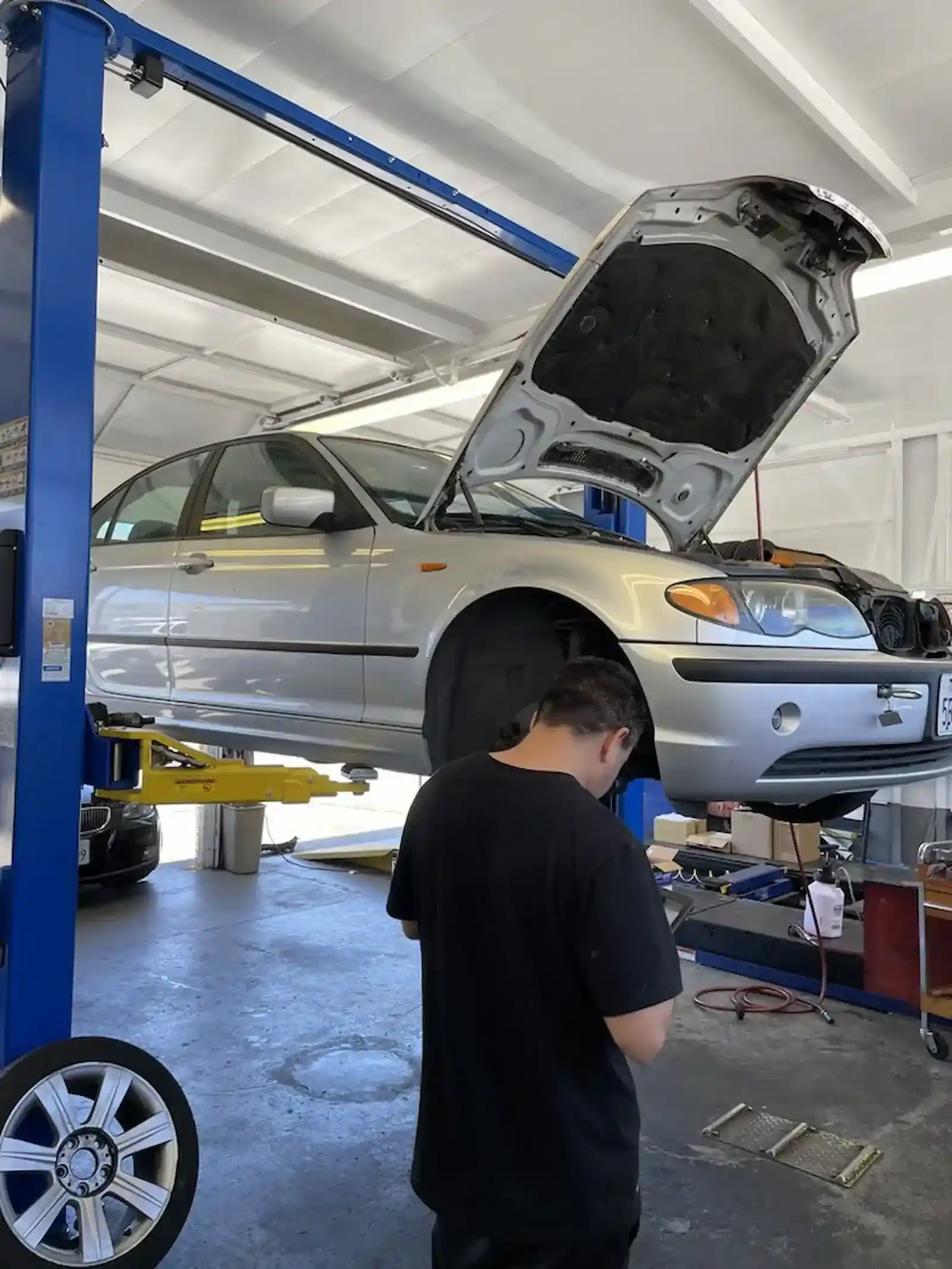 Beacon Auto Care technician performing brake repair on a BMW in San Mateo, CA