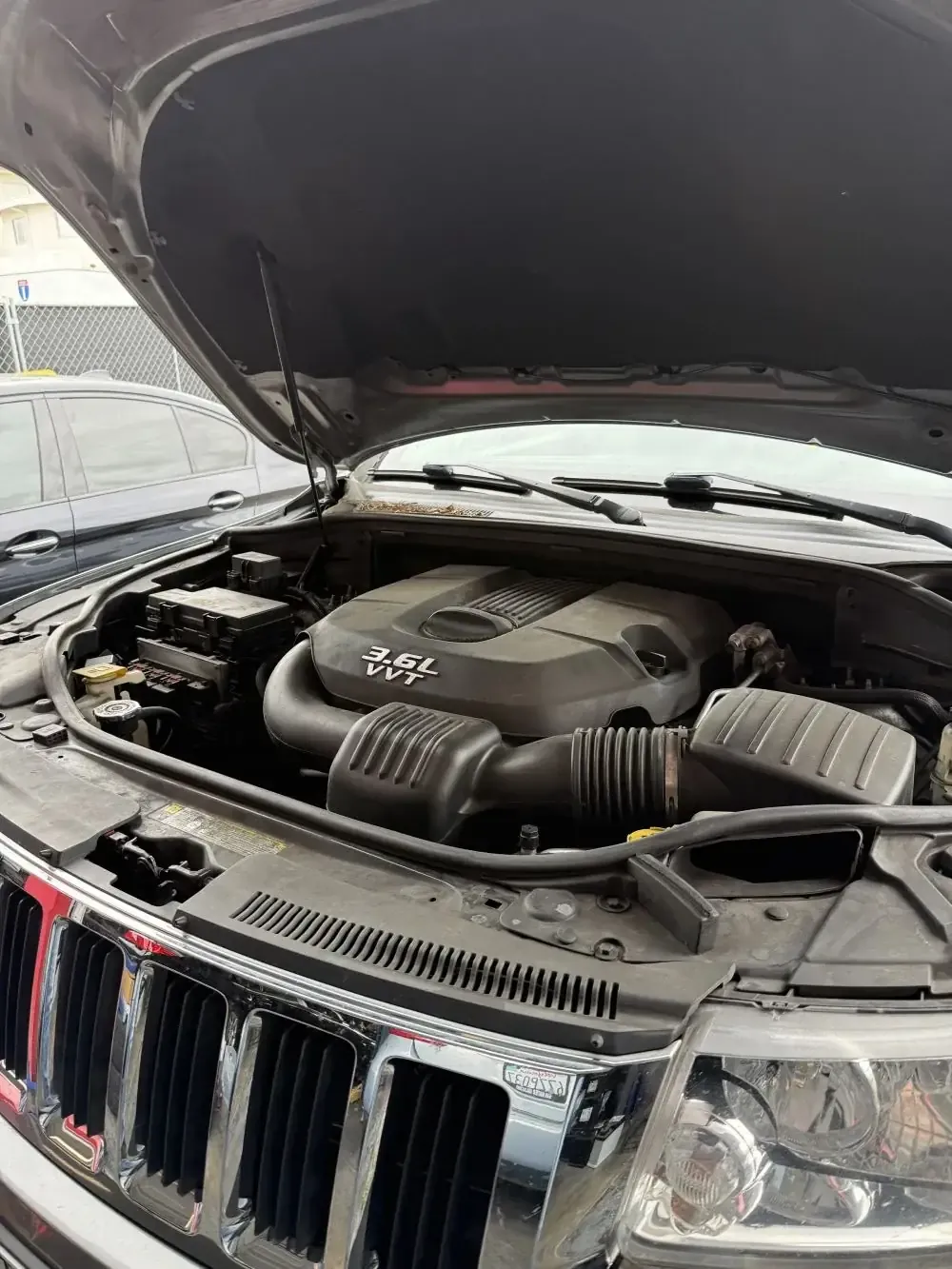 Jeep Grand Cherokee 3.6L Pentastar V6 engine bay open for scheduled maintenance at Beacon Auto Care San Mateo