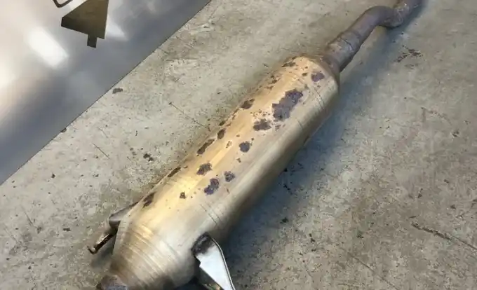 A removed muffler and resonator section on the shop floor at Beacon Auto Care San Mateo