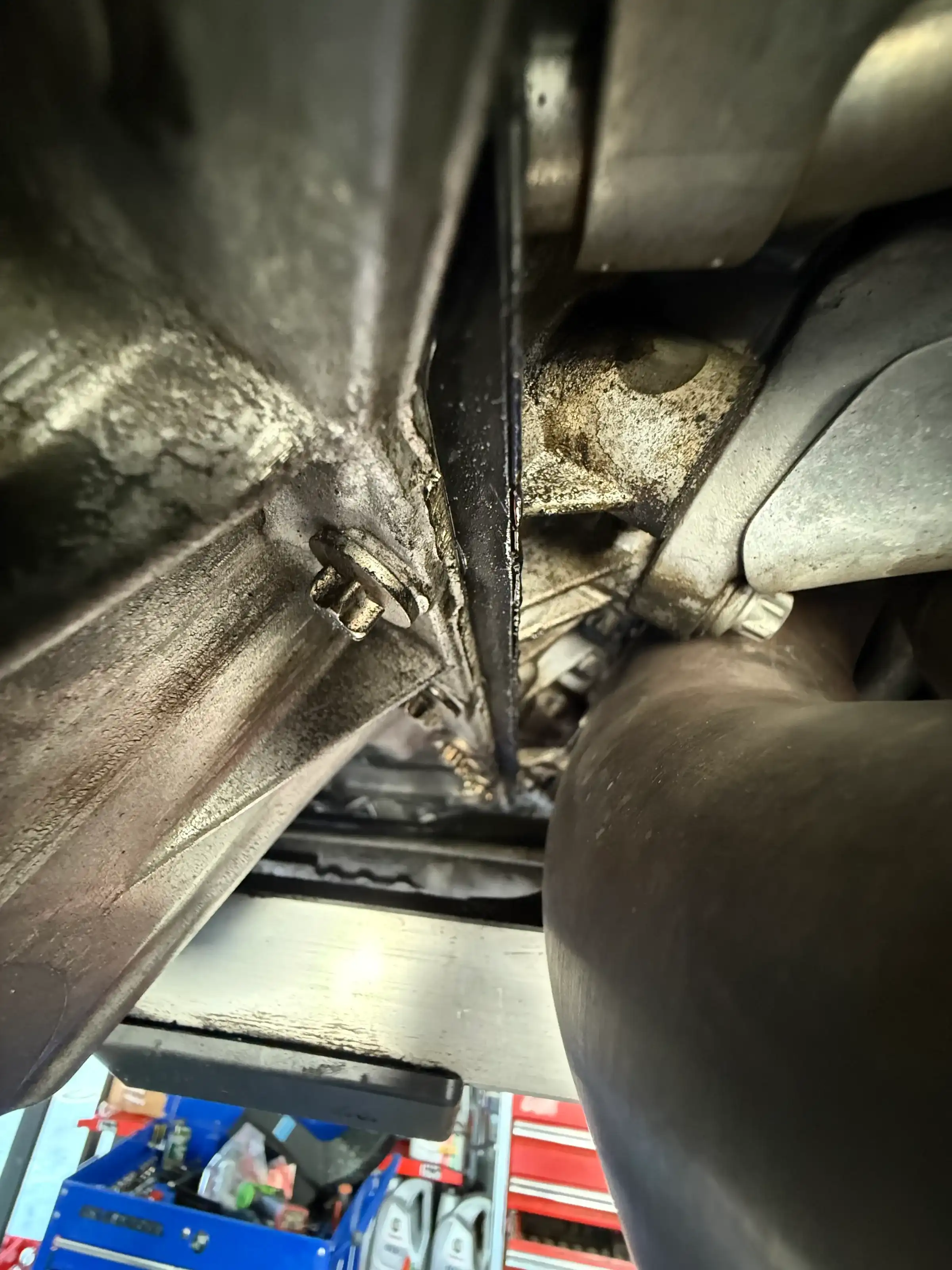 Underside view during suspension inspection at Beacon Auto Care San Mateo — control arm and subframe area